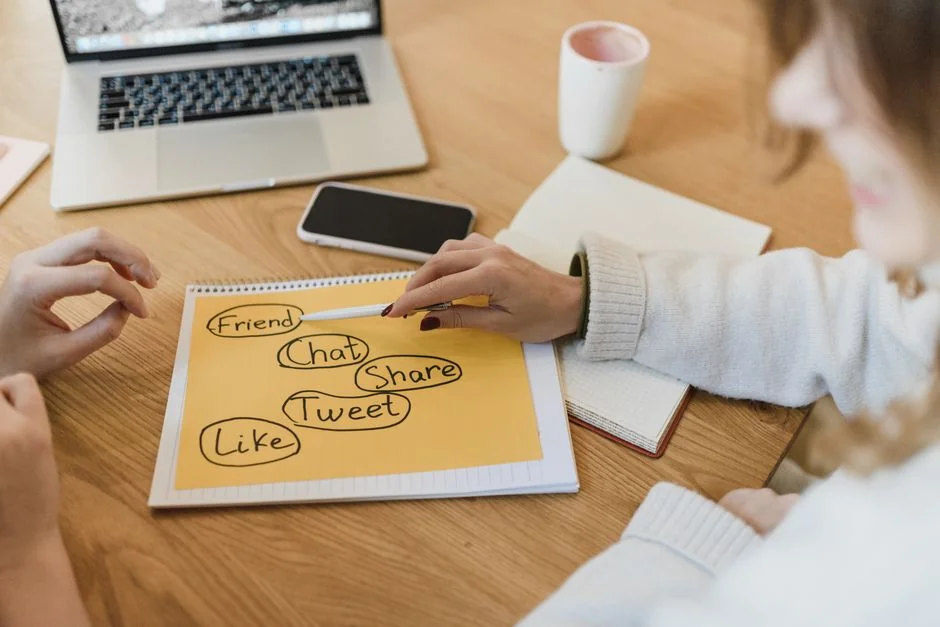 A modern workspace showing hands analyzing marketing data on a laptop and paper documents.